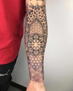 a man with a tattoo on his arm and leg is holding a flower of life