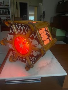 a decorative clock sitting on top of a table in front of a window with red light