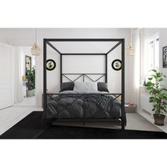 a black and white bedroom with a four poster bed, potted plant and window