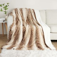 a white couch with a brown and white blanket on it