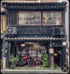 a motorcycle is parked in front of an old building with plants growing out of the windows