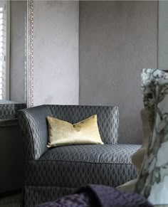 a chair with a pillow on it in front of a window