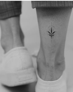 a woman's foot with a small flower tattoo on her left side ribcage