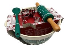 a christmas baking set in a bowl with rolling pin and cookie cutters on top