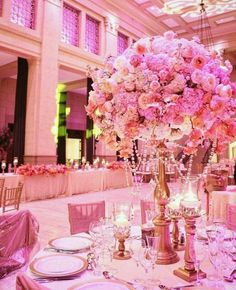 the centerpieces are filled with pink flowers and lit candles for an elegant wedding reception