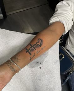 a person with a cross tattoo on their arm