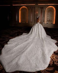 a woman in a wedding dress is standing on the floor with her back to the camera