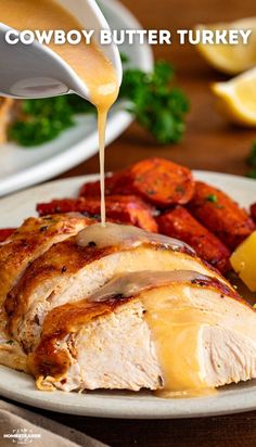 a person drizzling sauce onto a chicken breast on a plate with potatoes and carrots