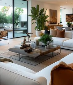 a living room filled with white couches and lots of plants on top of them