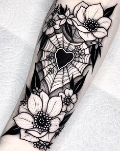 a black and white tattoo with flowers on the arm