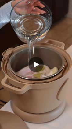 a person pouring liquid into a pot on top of a table