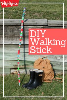 the diy walking stick is sitting on the grass next to a bag and boots