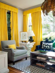 a living room filled with furniture and yellow curtains