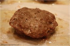 a hamburger pattie sitting on top of a piece of wax paper