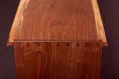 a close up of a wooden table on a black surface