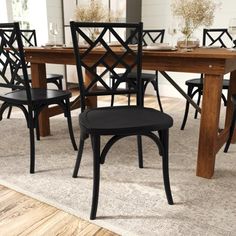 a dining room table with chairs and a rug on the floor in front of it