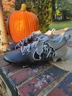 a pair of nike shoes sitting on top of a brick wall next to a pumpkin