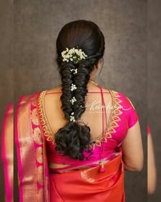 a woman in a red sari with flowers in her hair