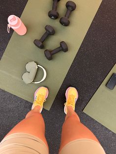 a person standing in front of some dumbs and other exercise equipment on the floor