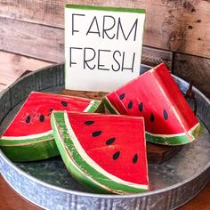 watermelon slices in a metal bowl with a sign that says farm fresh