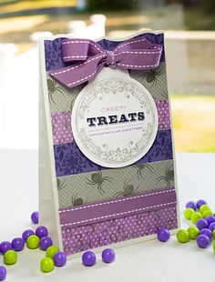 a purple and green treat bag next to some candies