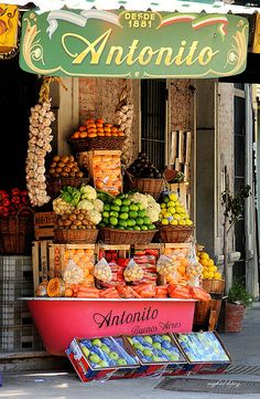 an assortment of fruits and vegetables on display in front of a storefront with the word antonio written above it