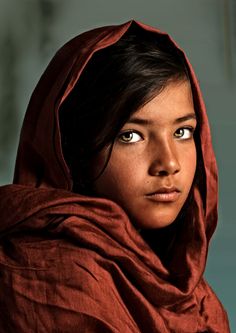 a young woman in a red shawl looking at the camera with an intense look on her face