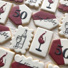 decorated cookies with wine and glasses are on the table for someone's 50th birthday