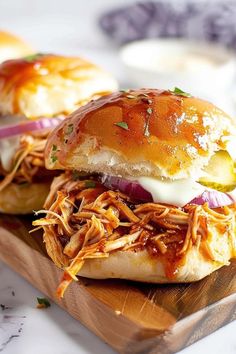 two pulled pork sandwiches on a cutting board