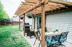 an outdoor patio with chairs, table and grill