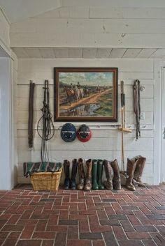 there is a painting hanging on the wall next to some boots and other things in front of it