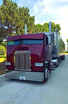 a red semi truck is parked on the side of the road