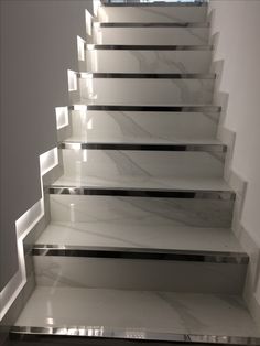 a set of stairs with white marble treads