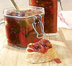 two jars filled with jam sitting on top of a wooden table