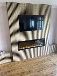 a living room with a tv mounted on the wall and a fire place in front of it