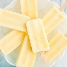 four popsicles on a plate with wooden sticks