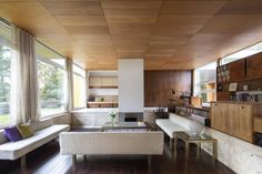 a living room filled with lots of furniture next to large windows on top of a hard wood floor