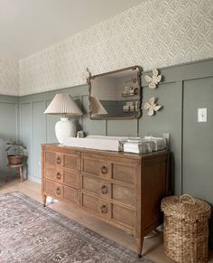 a baby's crib in the corner of a room with a rug and lamp