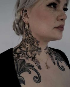 a woman with tattoos on her neck and chest