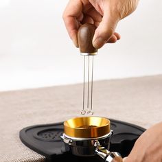 a person is stirring something in a small saucer on a stove with a wooden stick sticking out of it