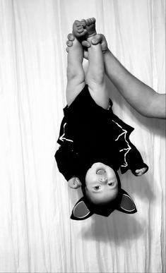 a black and white photo of a person holding a baby in the air with their hands