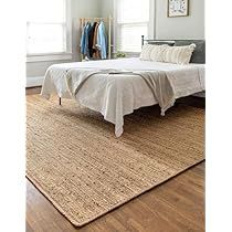 a bed sitting on top of a wooden floor next to a white dresser and window