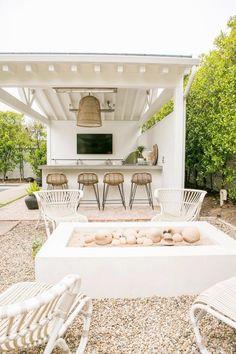 an outdoor living area with chairs and a fire pit