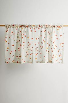 two curtains hanging on a clothes line with polka dot print and orange dots in the background