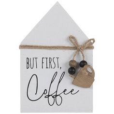 a sign that says but first, coffee with a key hanging from it's side