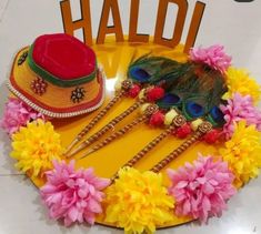 the hat is decorated with flowers and feathers on the table next to other items that have been placed on it