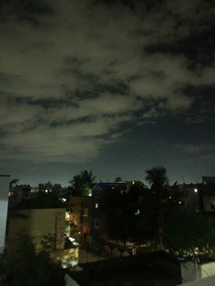 the sky is very dark and cloudy at night, with some buildings in the foreground