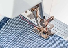 the sewing machine is working on some blue material that has been stitched together to make it easier for someone to sew