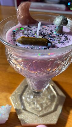 a glass filled with liquid sitting on top of a table next to small candies