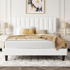 a large white bed sitting on top of a wooden floor